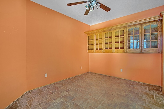 spare room with a textured ceiling and ceiling fan