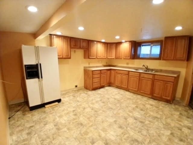 kitchen with sink and white refrigerator with ice dispenser