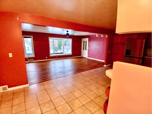 unfurnished living room with ceiling fan and tile patterned floors