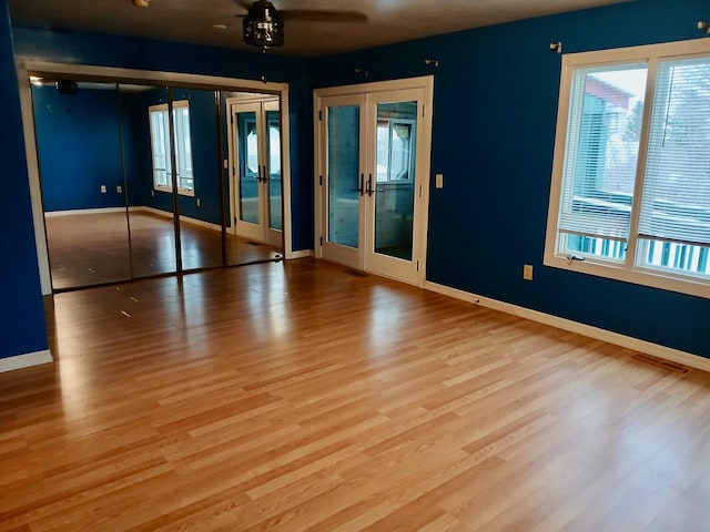 unfurnished room featuring hardwood / wood-style floors, ceiling fan, and french doors