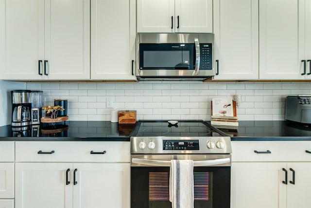 kitchen featuring stainless steel appliances, tasteful backsplash, and white cabinets