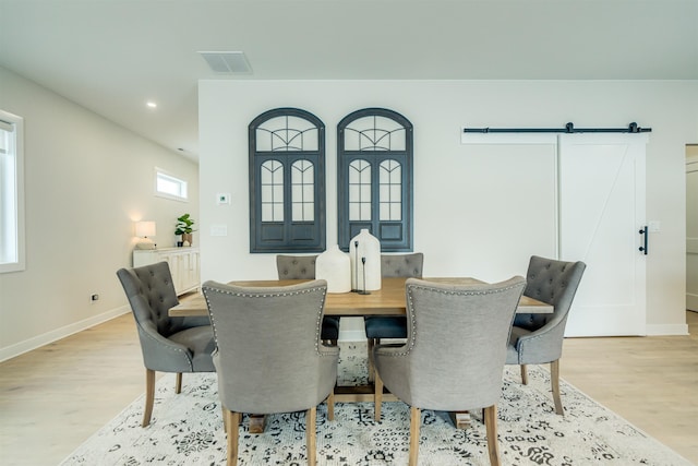 dining room featuring light hardwood / wood-style flooring and a barn door