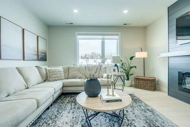 living room featuring a large fireplace and light hardwood / wood-style floors