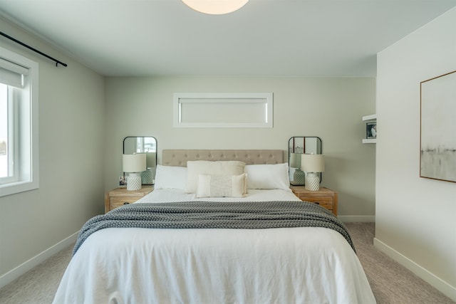 bedroom with multiple windows and light colored carpet