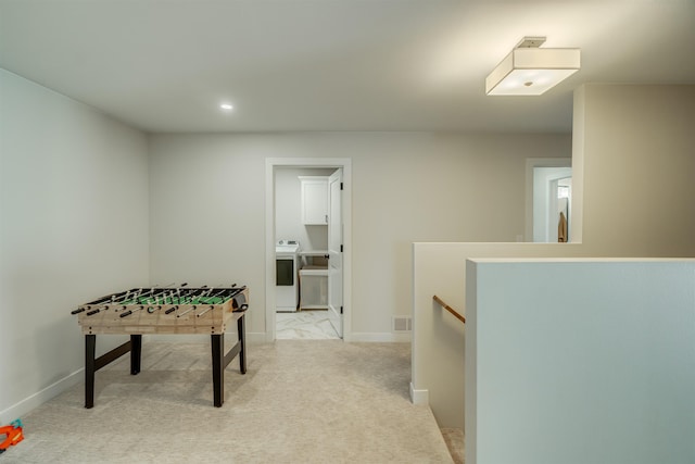 rec room with light colored carpet and washer / dryer