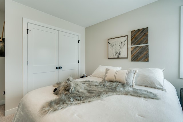 bedroom featuring light carpet and a closet