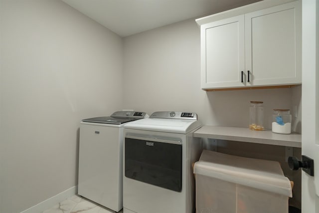 washroom featuring cabinets and independent washer and dryer