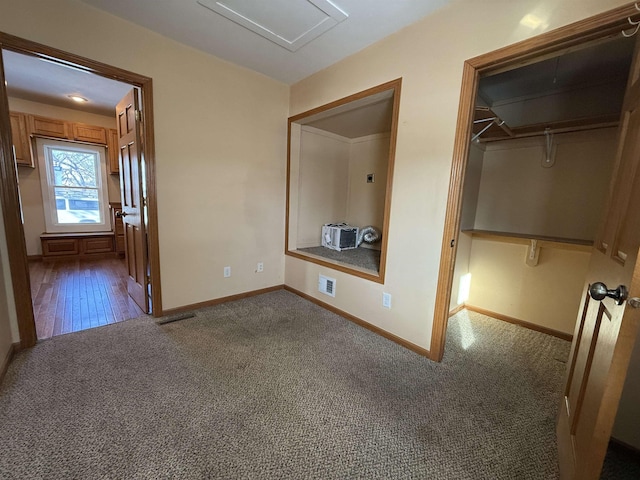 unfurnished bedroom featuring dark carpet and a closet