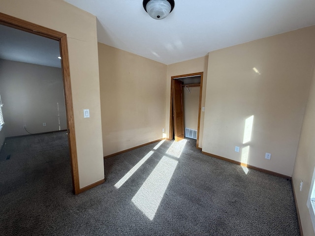 unfurnished room with dark colored carpet