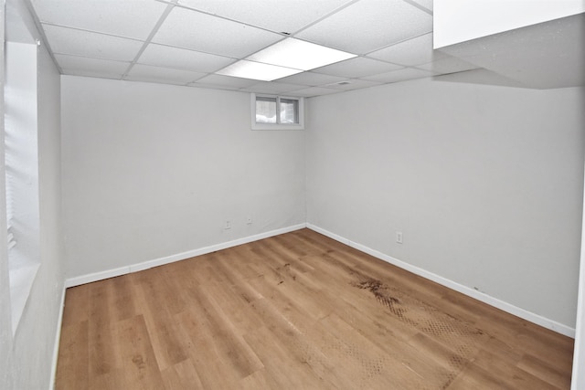 basement featuring a paneled ceiling and wood-type flooring