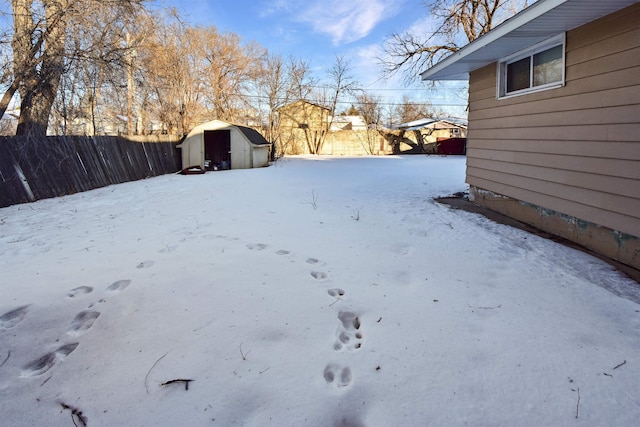 yard layered in snow featuring a storage unit