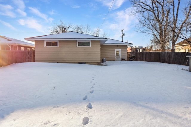 view of snow covered rear of property