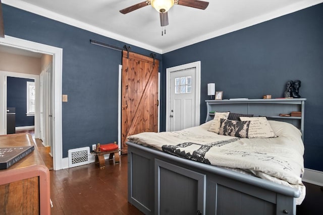 bedroom with ceiling fan, a barn door, and dark hardwood / wood-style flooring