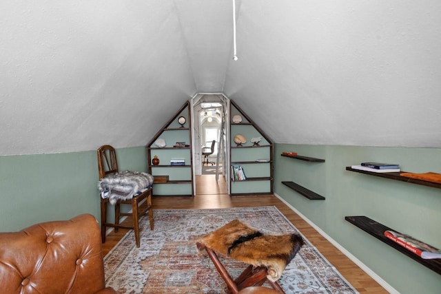 interior space with hardwood / wood-style flooring, vaulted ceiling, and a textured ceiling