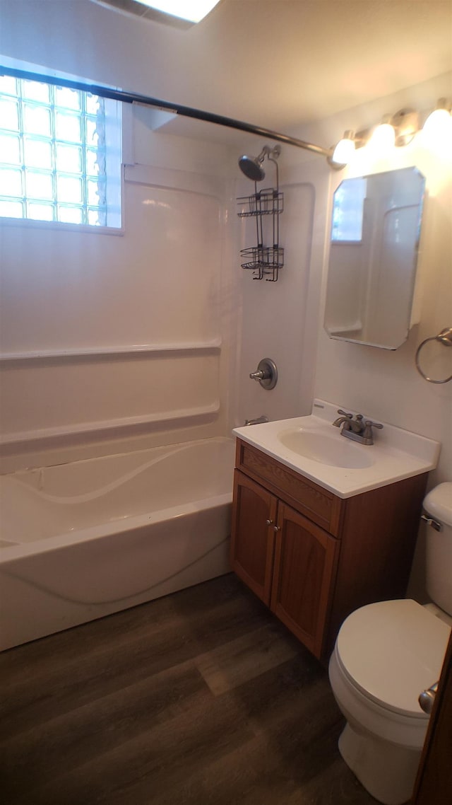 full bathroom featuring wood-type flooring, toilet, bathing tub / shower combination, and vanity