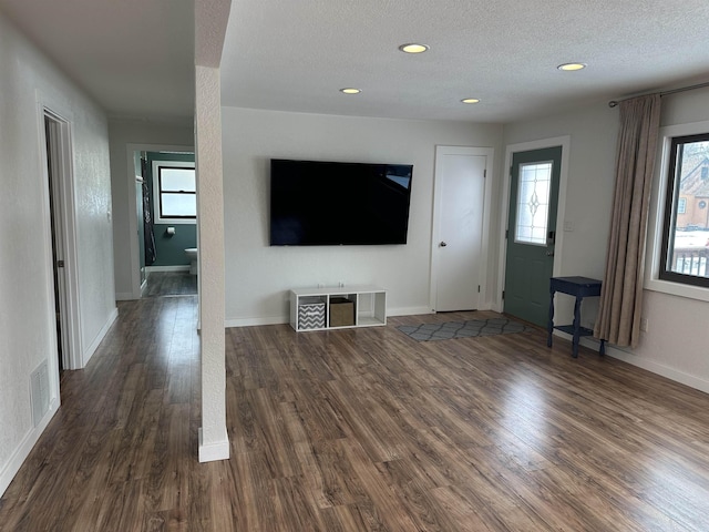 unfurnished living room featuring dark hardwood / wood-style floors and a textured ceiling