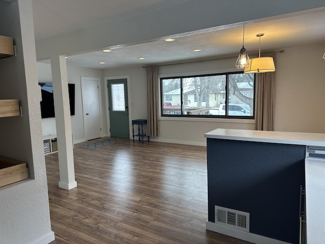 unfurnished living room with dark hardwood / wood-style flooring and a textured ceiling