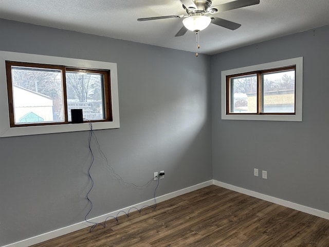 unfurnished room with dark wood-type flooring, a wealth of natural light, and ceiling fan