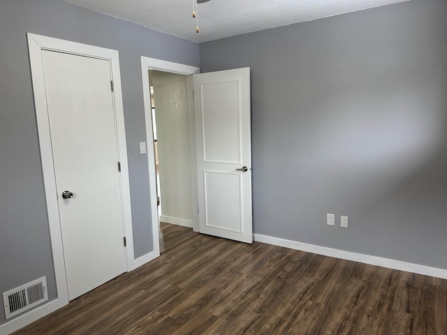 unfurnished bedroom with dark wood-type flooring