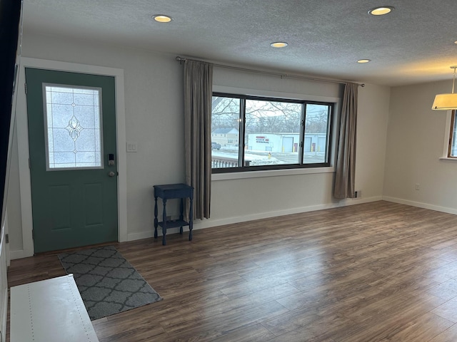 entrance foyer with dark hardwood / wood-style flooring and a textured ceiling