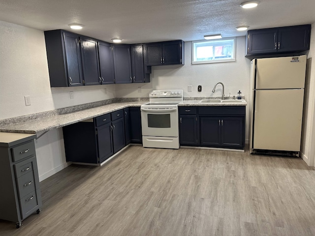 kitchen with sink, white appliances, light hardwood / wood-style floors, and a textured ceiling