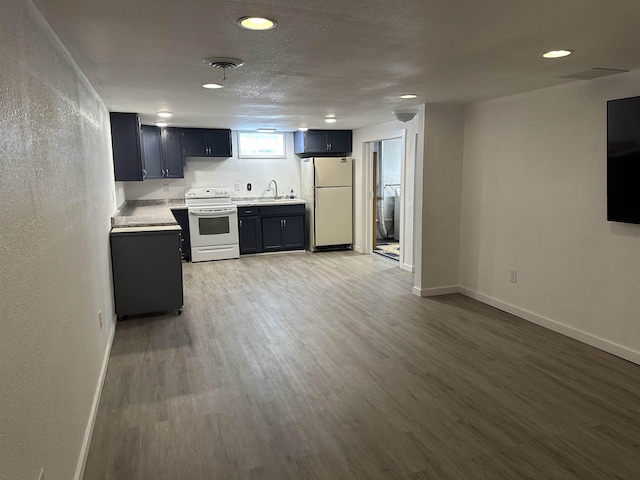 kitchen with electric stove, sink, light hardwood / wood-style flooring, fridge, and a textured ceiling