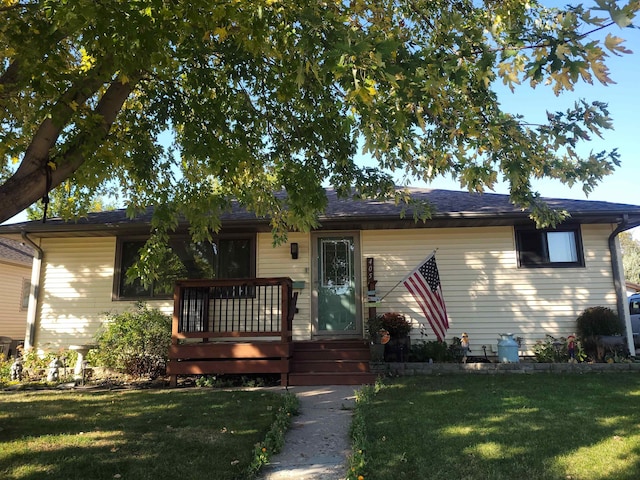 view of front facade with a wooden deck and a front yard