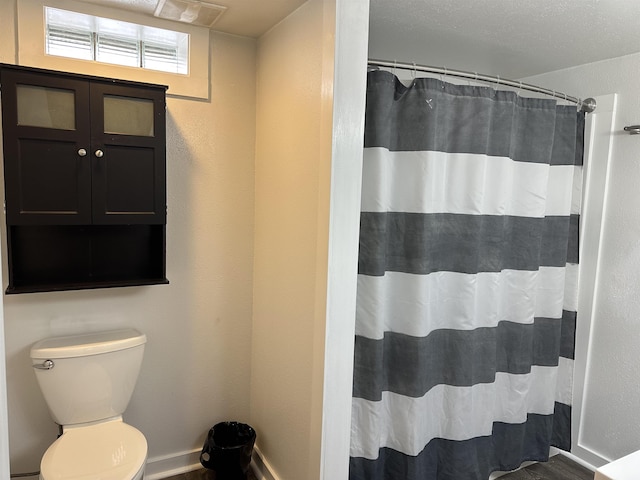 bathroom with toilet and a shower with shower curtain