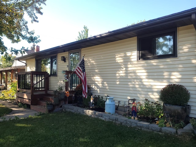 view of front of property with a deck and a front lawn