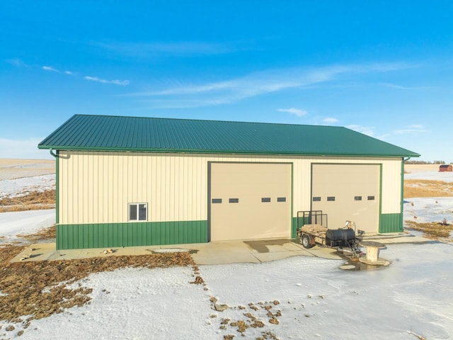 snow covered structure with a garage