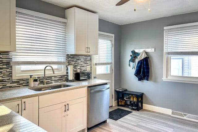 kitchen with sink, tasteful backsplash, light hardwood / wood-style flooring, dishwasher, and white cabinets