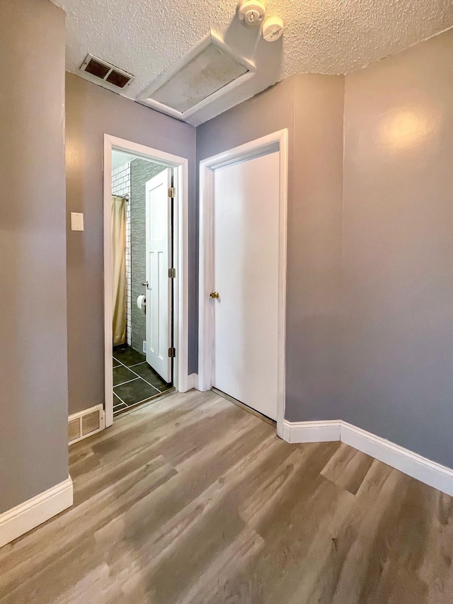 hall featuring hardwood / wood-style flooring and a textured ceiling