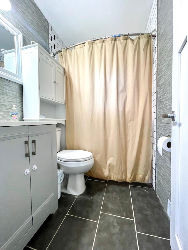 bathroom with a shower with curtain, tile patterned floors, toilet, and vanity