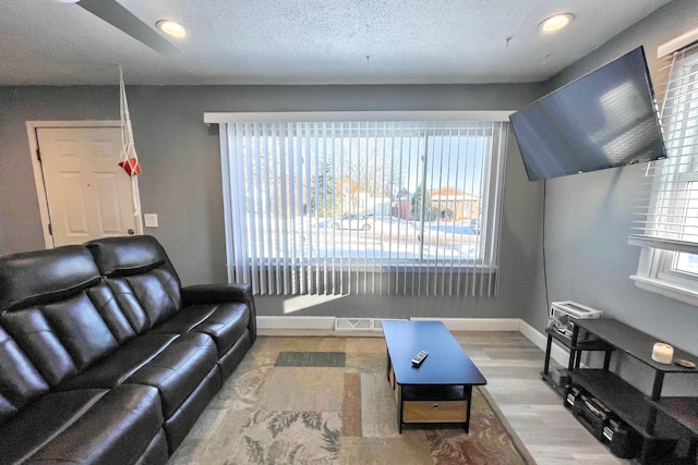 living room featuring a textured ceiling and light hardwood / wood-style floors