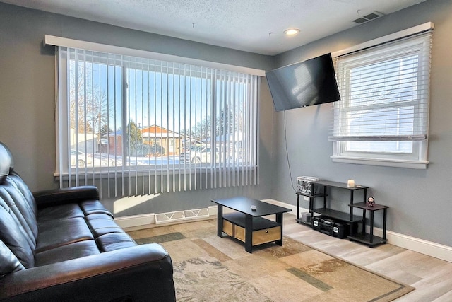 living room featuring a textured ceiling and light wood-type flooring