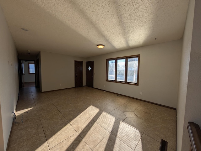 spare room with light tile patterned floors and a textured ceiling