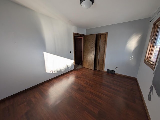 spare room with dark wood-type flooring