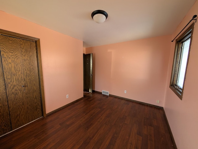 unfurnished bedroom with dark hardwood / wood-style flooring