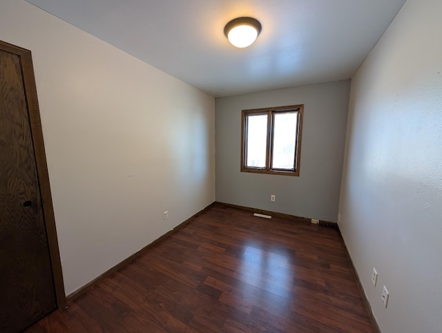 spare room with dark hardwood / wood-style floors