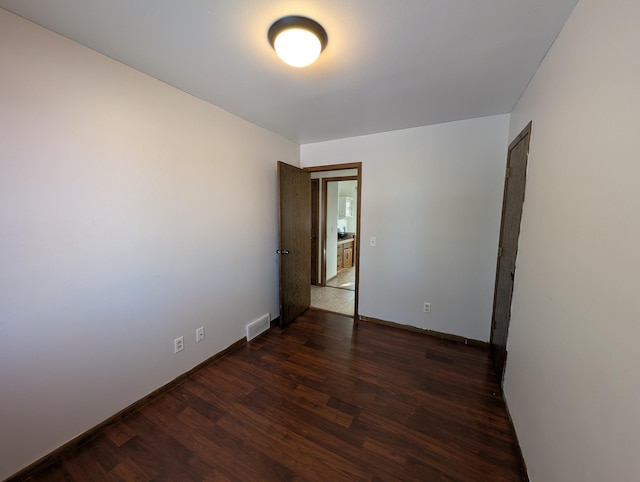 empty room with dark hardwood / wood-style flooring