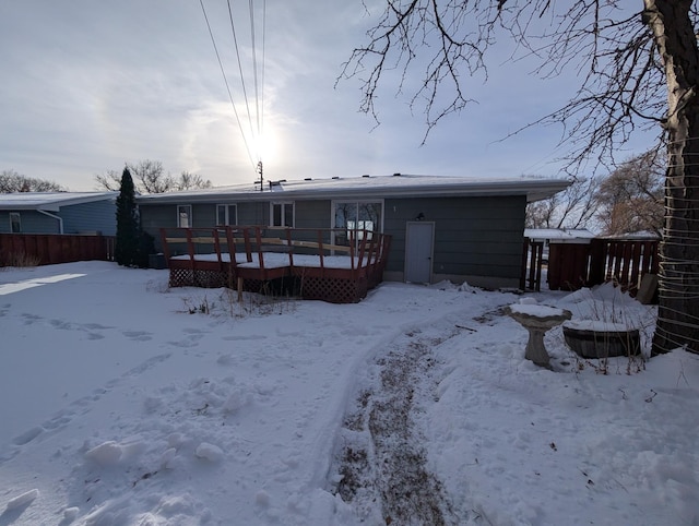 snow covered house featuring a deck