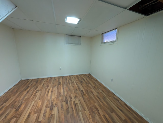 basement featuring dark hardwood / wood-style flooring and a drop ceiling