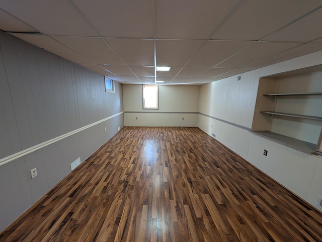 basement with dark wood-type flooring and a drop ceiling