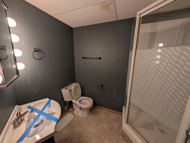 bathroom with toilet, a paneled ceiling, vanity, and walk in shower