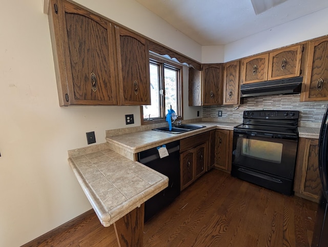 kitchen with sink, dark wood-type flooring, backsplash, tile counters, and black appliances