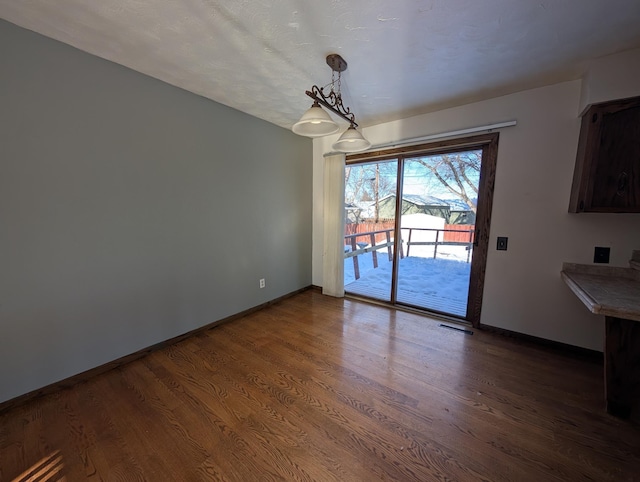 unfurnished dining area with dark wood-type flooring