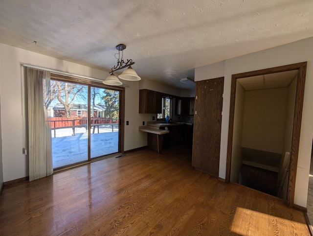 kitchen featuring hardwood / wood-style flooring, dark brown cabinetry, sink, and a textured ceiling