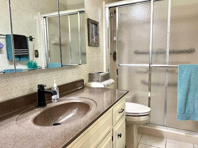 bathroom with tile patterned floors, toilet, a shower with shower door, and vanity