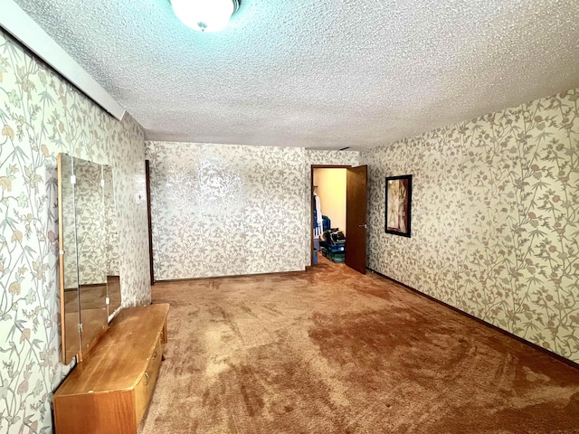 carpeted empty room with a textured ceiling