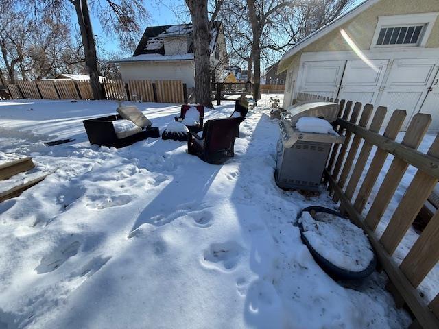 4 10th St, Minot, ND 58701 - snowy yard with a garage and fence
